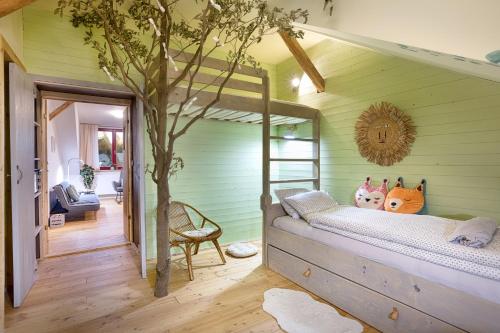 sypialnia z łóżkiem piętrowym i drzewem w obiekcie Apartmány v domečku w mieście Hlinsko