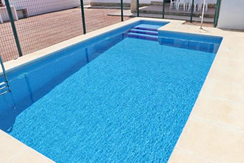 a large blue swimming pool with blue water at Chalet Pinar de Roche in Conil de la Frontera