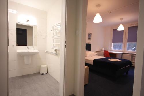 シュチェチンにあるStudencki Dom Marynarza Pasatのベッドルーム1室(ベッド1台、シンク付)、バスルーム1室が備わります。