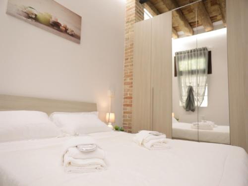 a bedroom with a white bed with towels on it at PRATO DELLA VALLE STUDIO in Padova