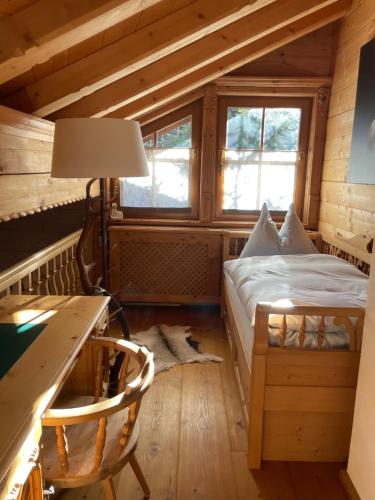 a bedroom in a log cabin with a bed and a desk at Maris Luxus-Bergvilla in Bodensdorf