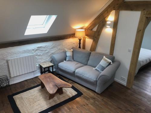 a living room with a couch and a table at Le Séchoir in Beaulieu-sur-Dordogne