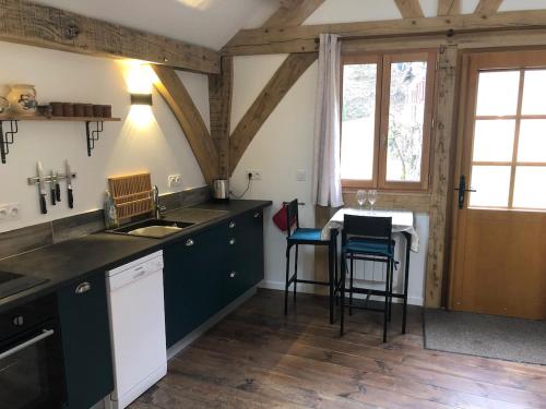 a kitchen with a sink and a table with chairs at Le Séchoir in Beaulieu-sur-Dordogne