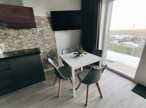 a white table and chairs in a kitchen with a window at K-Town - Apartments ViaBaltic Kaunas in Kaunas