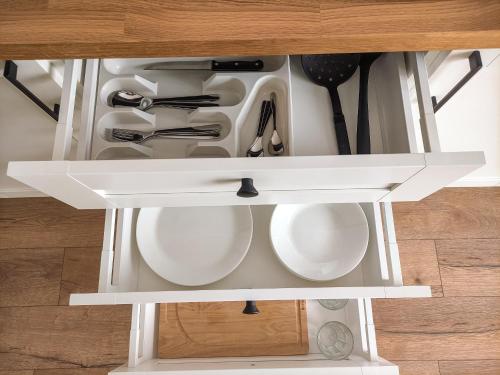 a drawer in a cabinet filled with kitchen utensils at K-Town - Apartments ViaBaltic Kaunas in Kaunas