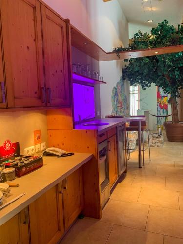 a kitchen with wooden cabinets and a purple light at Landhotel Bauernschmitt in Pottenstein