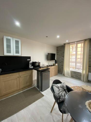 un salon avec une table et une cuisine dans l'établissement Le Glacier, à Dieppe