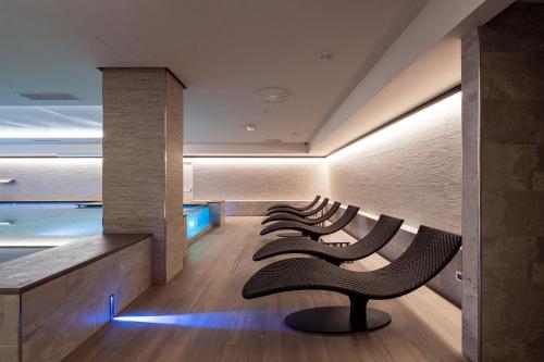 a row of chairs sitting in a row in a room at Smy Carlos V Wellness & Spa Alghero in Alghero