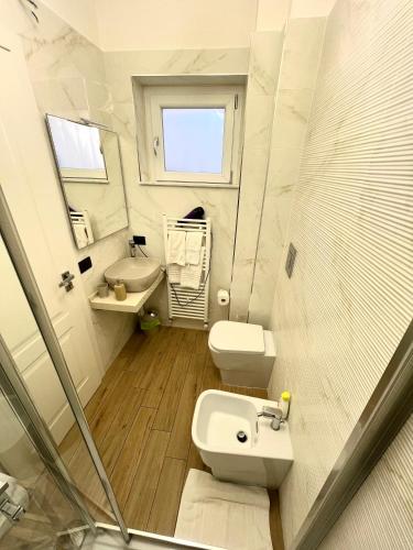 a white bathroom with a sink and a toilet at Rooms lungomare in Crotone