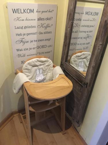 une chaise en bois devant un miroir dans l'établissement Haus Horizont, à Dyksterhusen