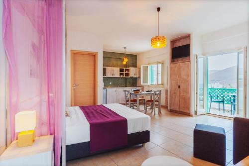 sypialnia z łóżkiem, kuchnia i stół w obiekcie Aelia Apartments & Suites w mieście Livadi Astypalaias