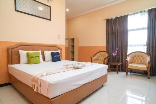 un dormitorio con una cama con un animal de peluche en Urbanview Hotel de Kopen Malang by RedDoorz, en Malang