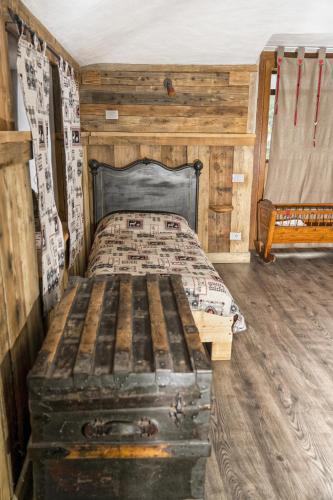 a bed in a wooden room with a wooden floor at Agriturismo B&B Chèvres à Cheval in Aosta