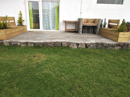 a backyard with a stone patio with a fireplace at Changement d'air près du volcan in Le Tampon