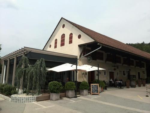 un grand bâtiment avec des parasols dans un parking dans l'établissement Pr Kopač, à Brezovica