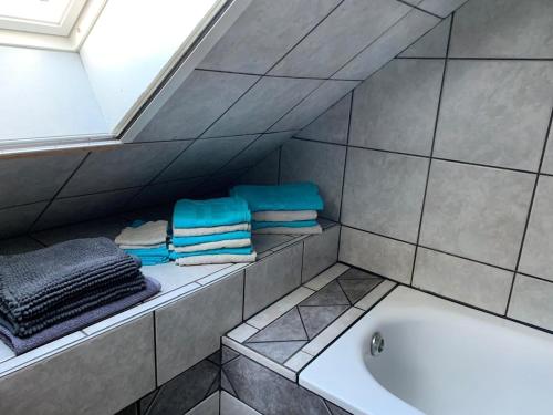 a bathroom with a sink and a tub and towels at Vierseitenhof Hasenfelde - Ferienwohnung Feldblick in Steinhöfel