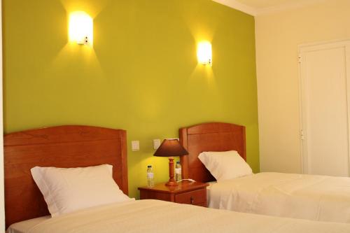 1 dormitorio con 2 camas y 2 luces en la pared en Canto do Rossio, en Vidigueira