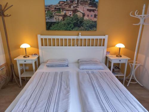 a bedroom with a white bed with two tables at Haus mit mediterranem Flair in Gschwandt