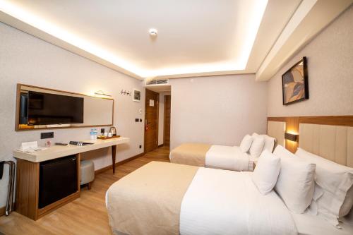 a hotel room with two beds and a desk at Erboy Hotel Istanbul Sirkeci in Istanbul