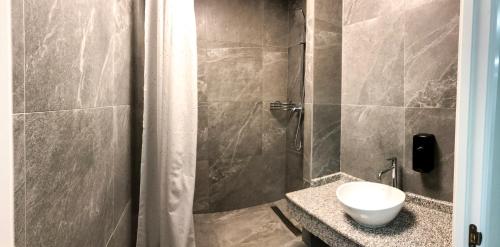 a bathroom with a shower with a sink and a toilet at Hostel City Center in Chişinău