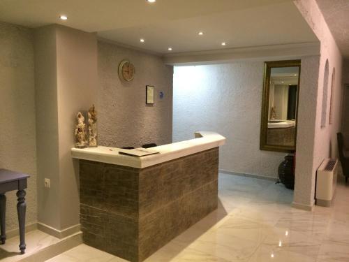 a bathroom with a tub, sink and mirror at Valentino Hotel in Kremasti