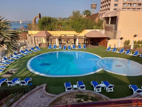 - une piscine avec des chaises longues et un complexe dans l'établissement Lotus Luxor Hotel, à Louxor