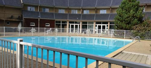 a large swimming pool in front of a building at Appartement avec piscine près de Honfleur in Équemauville