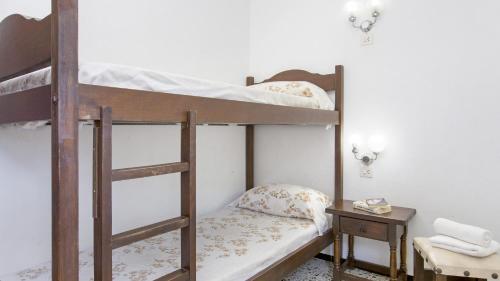 two bunk beds in a room with a table at 1Benet 1 - Calella de Palafrugell in Calella de Palafrugell