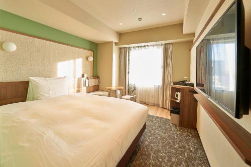 a hotel room with a bed and a flat screen tv at Keisei Richmond Hotel Tokyo Kinshicho in Tokyo