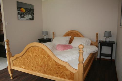 een slaapkamer met een houten bed met een roze kussen erop bij BnB Le Loft Im Fang in Im Fang