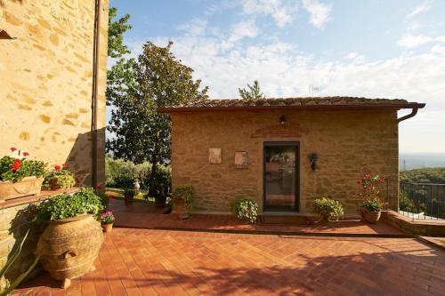 a building with a patio with plants and flowers at Villa Vestra in Vinci holiday home in Vinci