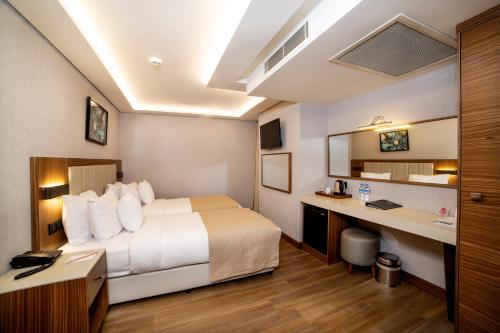 a hotel room with a bed and a desk at Erboy Hotel Istanbul Sirkeci in Istanbul