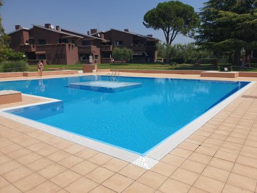 a large swimming pool with blue water in a yard at APARTMENTS BLUE VIEW - Regarda Travel in Bardolino