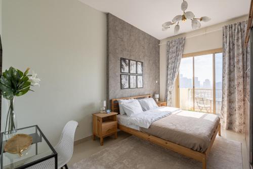 um quarto com uma cama e uma mesa de vidro em HiGuests - Luxurious 1BR Apartment with balcony in JVC em Dubai