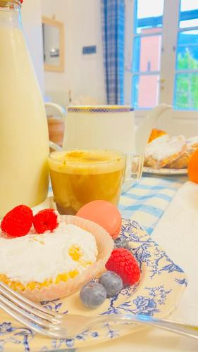 a table with a cup of orange juice and a pie with berries at Villa Arancia Quiet, Central, Parking and Air Conditioning in Levanto