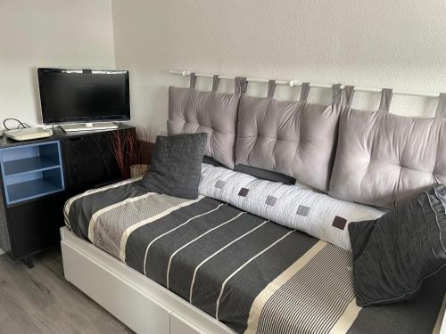 une chambre avec un grand lit et une télévision dans l'établissement Appart à la plage, à Saint-Jean-de-Monts