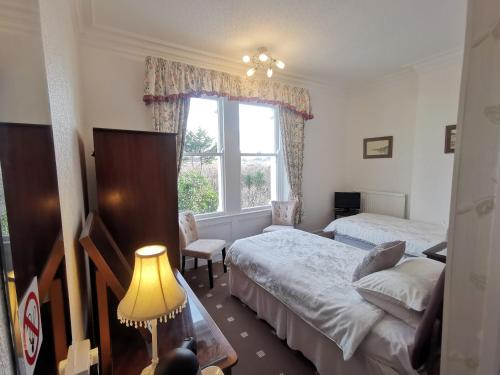 a bedroom with two beds and a window at Bron Orme Private Hotel in Llandudno