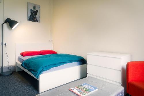a bedroom with a bed and a red chair at Princes Street Hostel in Edinburgh