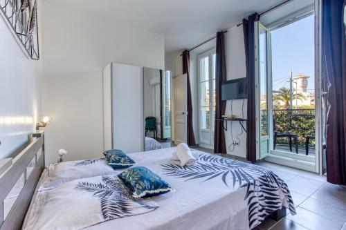 ein Schlafzimmer mit einem Bett und einem großen Fenster in der Unterkunft LE JEAN JAURES - REFAIT A NEUF, LUMINEUX, LONG BALCON, JOLIE VUE, WIFI, Cœur VIEUX-NICE in Nizza
