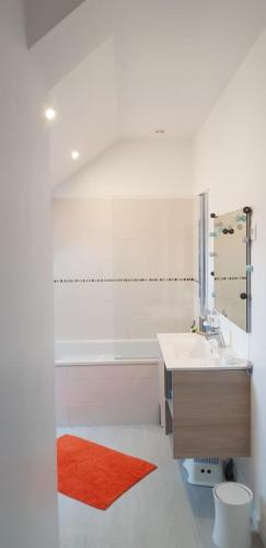 威斯特拉姆的住宿－Maison moderne plein coeur de Ouistreham，一间带水槽和红色地毯的浴室