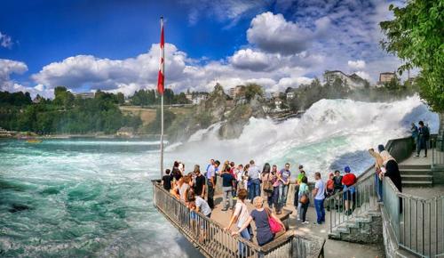 a large group of people standing in front of a waterfall at Hotel Schweizer Hof in Lottstetten