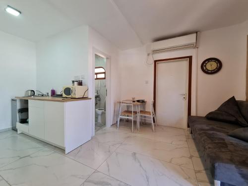 a kitchen and a living room with a couch and a table at Exodus Hostel & Dive Center in Eilat