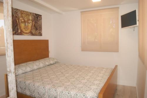1 dormitorio con 1 cama y una pintura en la pared en Villa Marineu Las Fuentes, en Alcossebre