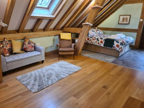 a attic room with a bed and a couch at Renovated Loft on Working Farm in Mayfield