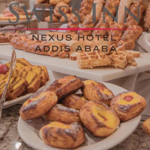 a display of various pastries on plates on a table at Swiss Inn Nexus Hotel in Addis Ababa