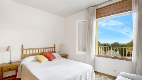 um quarto com uma cama e uma grande janela em Cen B-10 - Llafranc em Llafranc