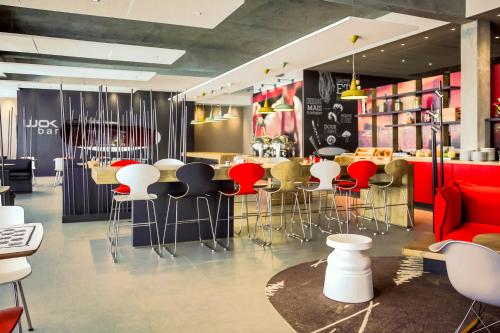 a restaurant with red and white stools and a bar at Ibis Rabat Agdal in Rabat