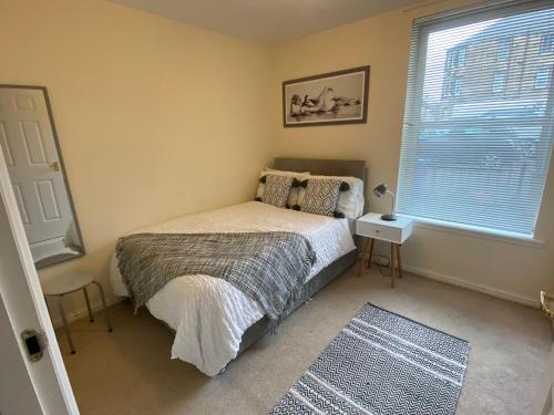 um quarto com uma cama e uma janela em Maltings Apartment - Spacious 2 Bed Ground Floor Apartment em Kirkcaldy