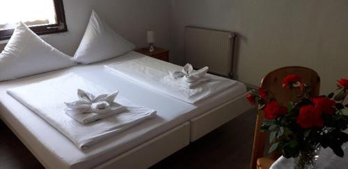 a bedroom with a bed with towels and flowers at Hotel Schweizer Hof in Lottstetten