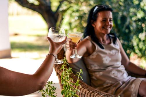 una mujer sosteniendo una copa de vino blanco en Royal Karoo Safari Lodge, en Steytlerville